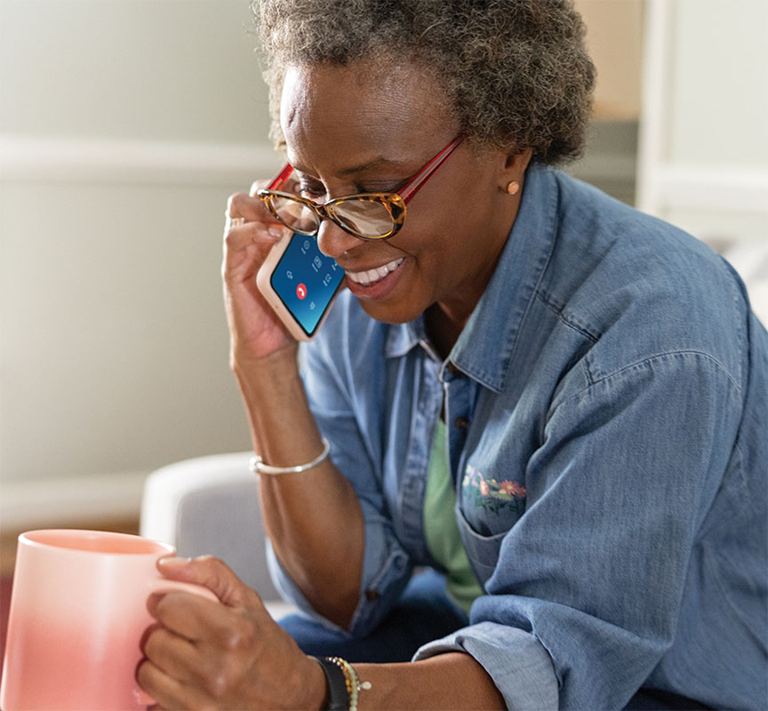 Lady on a phone call holding a mug.