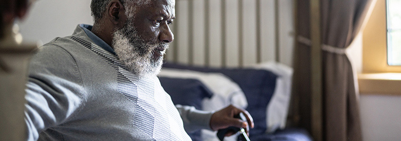Older black man white beard sitting with a cane, representing chronic disease in the U.S.