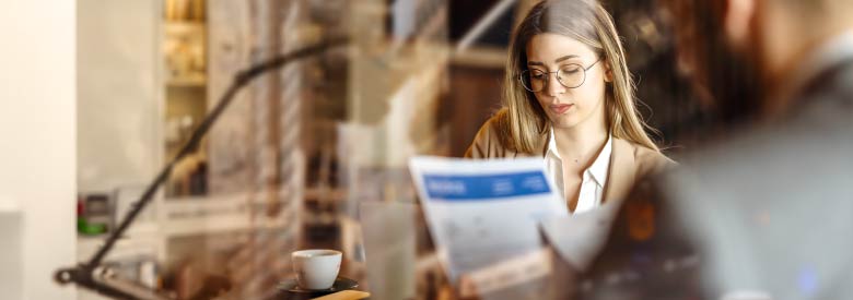 young female adult reading about her employee benefits plan