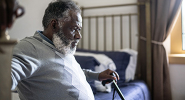 older man with a cane sitting