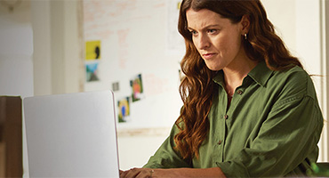 women on her laptop computer looking for a health care prior authorization