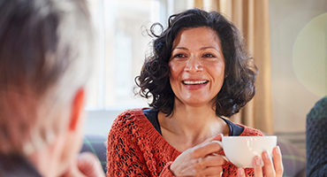 middle age women eating breakfast while reading his health insurance benefits handbook