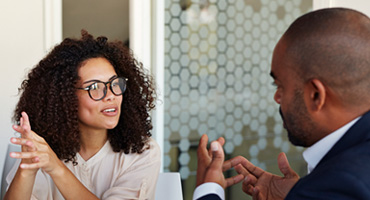 adult male talking to an adult women in a public setting