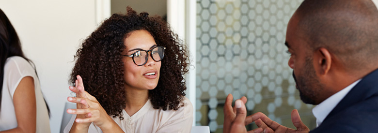 adult male talking to an adult women in a public setting