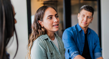 A group of young adult colleagues are sharing thoughts and ideas about how depression leads to Increased total cost of care with employees.