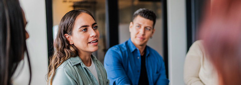 A group of young adult colleagues are sharing thoughts and ideas about how depression leads to Increased total cost of care with employees.
