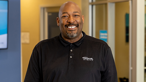 A Highmark advisor in a black shirt smiles in an office space.