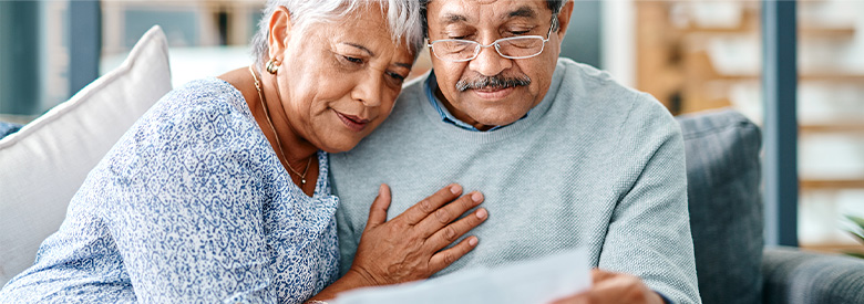 senior couple looking at their cost of health care retirement statements