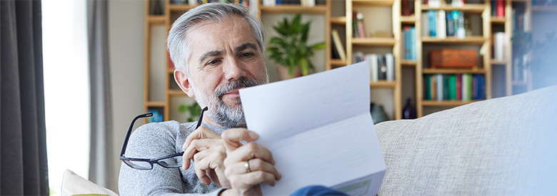 senior man looking at his health care paperwork and bills