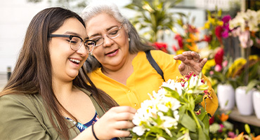 two women looking at flowers having a good time together