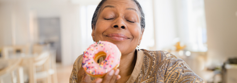 senior women looking at a donut