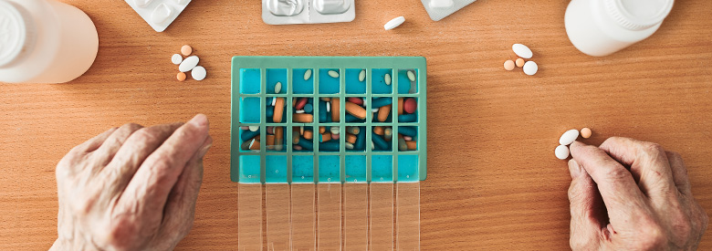 An older adult sorts their many medications, representing Highmark's Medicare Part D’s help with easily managing prescriptions.