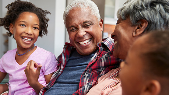 Joyful seniors and young children share a laugh, representing the family benefits of D-SNP qualification